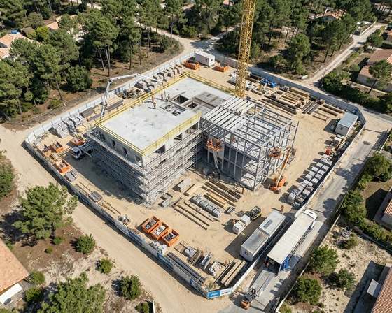Vue aérienne d’un chantier de logements collectifs en lisière de pinède